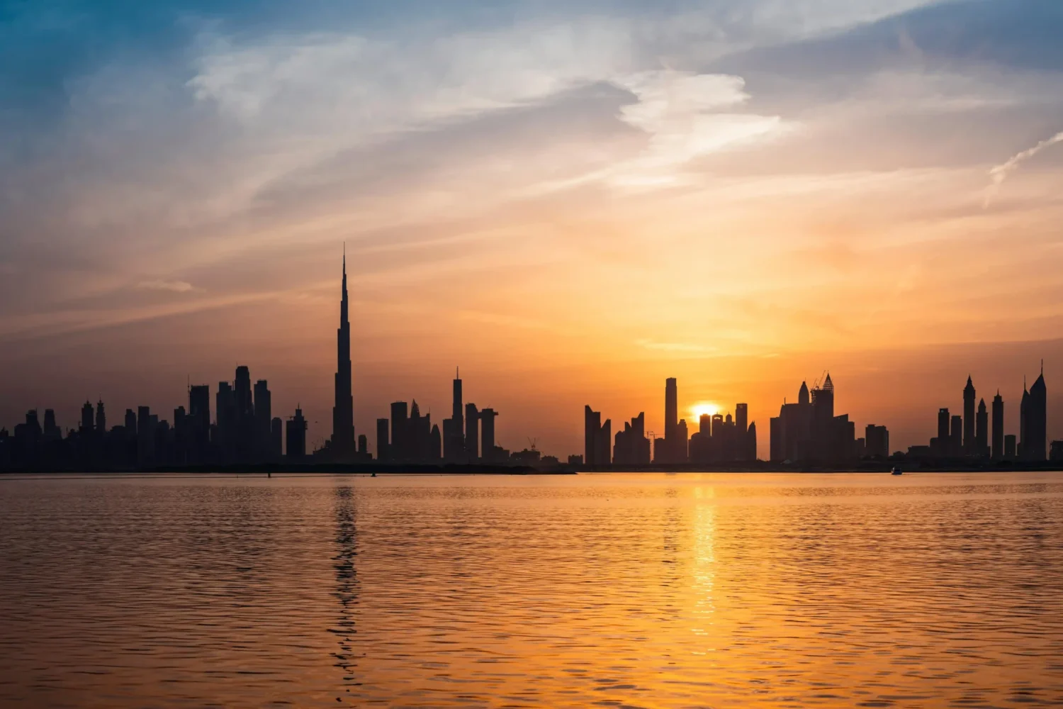 • Burj Khalifa in Dubai casting a shadow over the skyline, with sunlight illuminating the surrounding buildings
