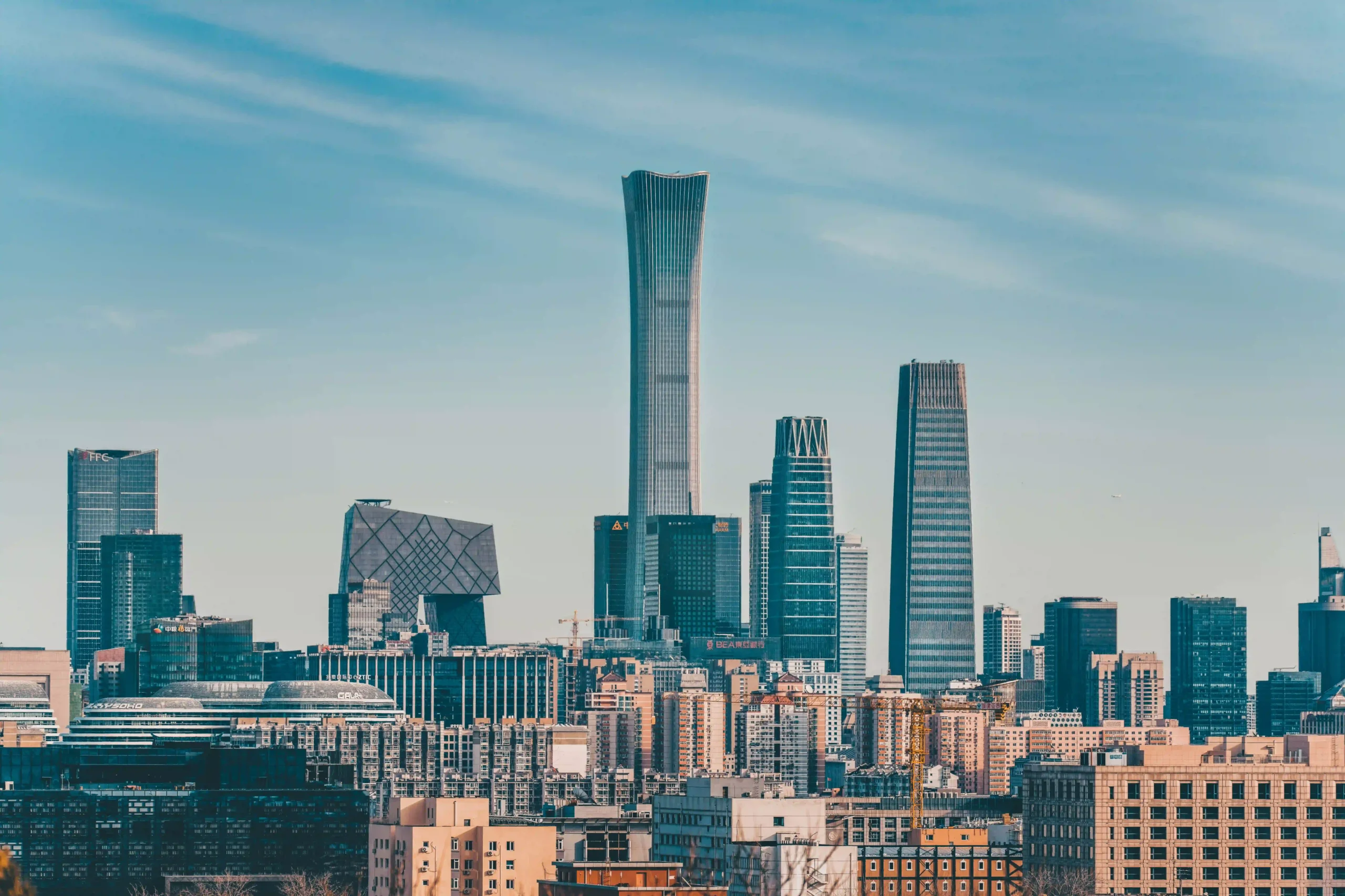 10 Tallest Buildings in the World (2025) A panoramic view of Beijing's skyline featuring prominent skyscrapers including the China Zun and the CCTV Headquarters, under a clear blue sky.