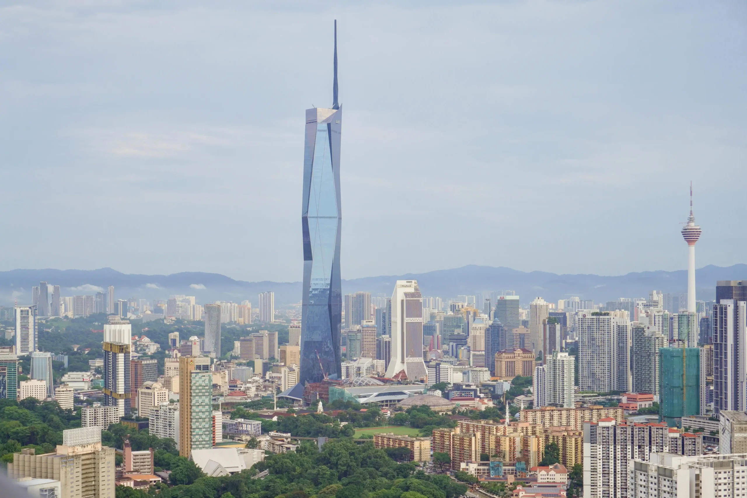 10 Tallest Buildings in the World (2025) Aerial view of the Merdeka 118 skyscraper in Kuala Lumpur, Malaysia, showcasing its distinct modern design against the city skyline.