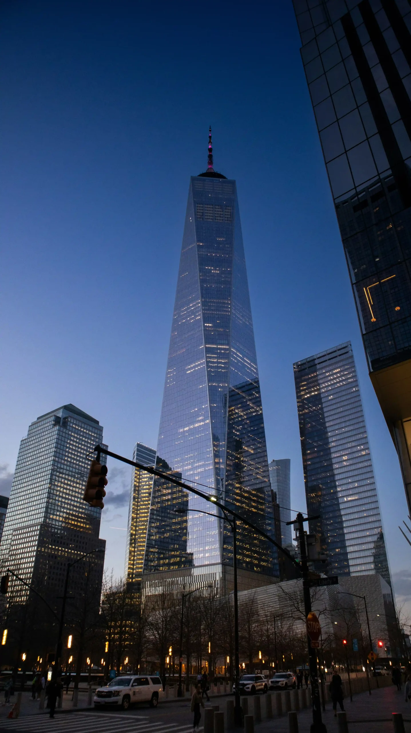 One World Trade Center: Stats, Architecture, and Fun Facts One World Trade Center towering against a twilight sky, showcasing its glass facade and iconic spire, surrounded by city buildings.