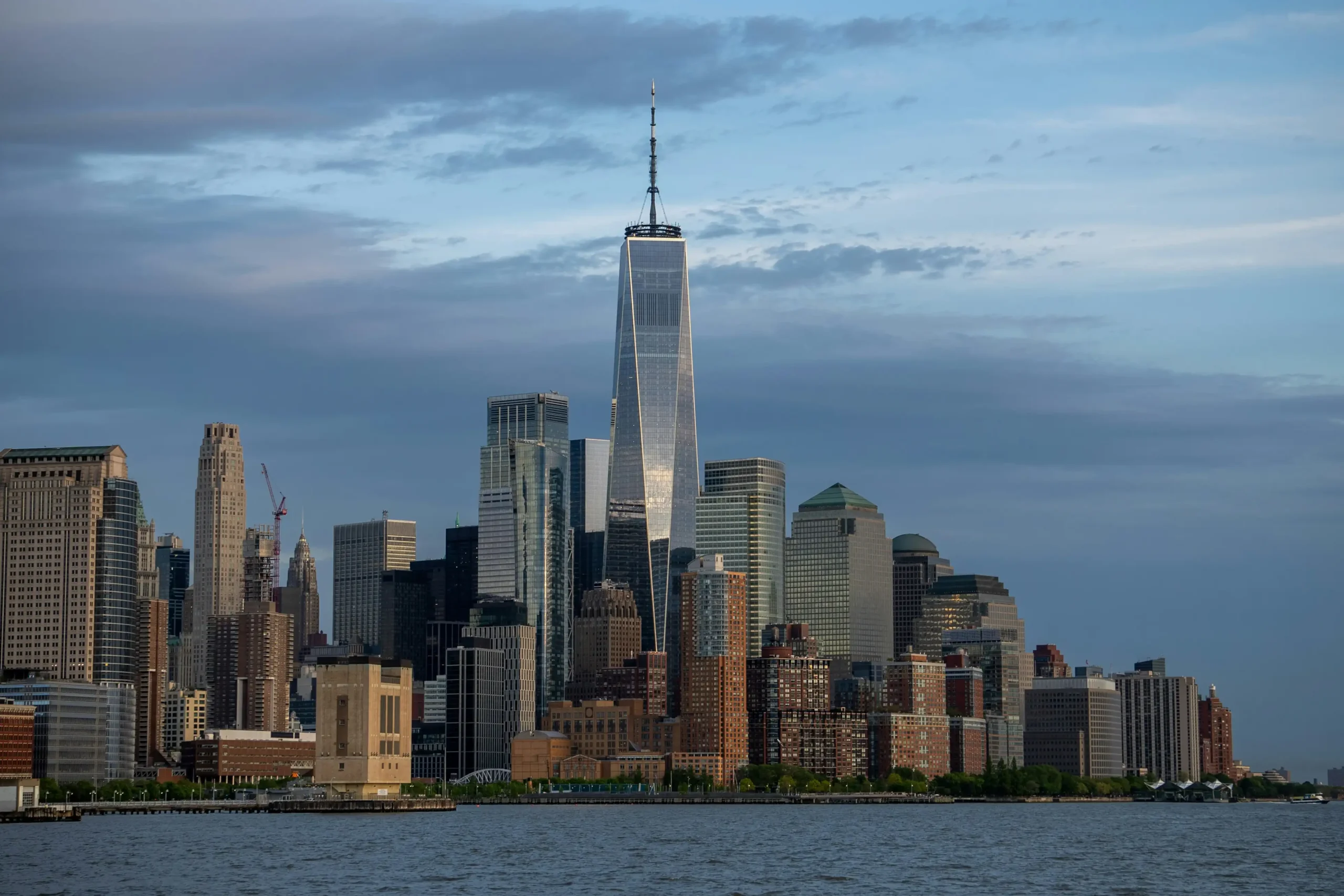 10 Tallest Buildings in the World (2025) One World Trade Center towering over the New York City skyline with various buildings in the foreground and a cloudy sky